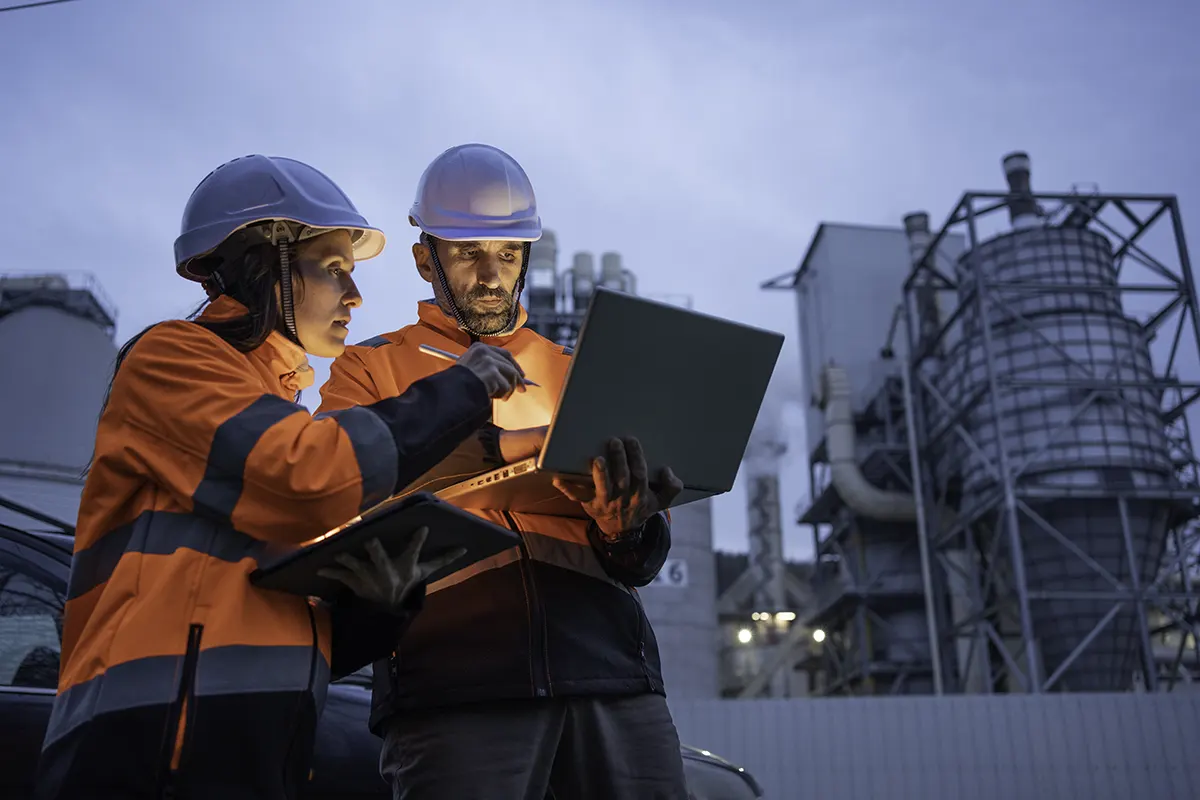 Deux ingénieurs travaillant avec un ordinateur portable sur un site industriel